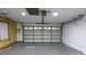 Spacious garage featuring an automatic door opener, painted walls, and concrete floor at 29341 Rhodin Pl, Wesley Chapel, FL 33545