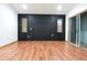 An open living room showcases a feature wall, wood floors, natural light and sliding door access at 29341 Rhodin Pl, Wesley Chapel, FL 33545