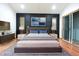 Modern primary bedroom featuring hardwood floors, a mounted TV, and sliding glass doors at 29341 Rhodin Pl, Wesley Chapel, FL 33545