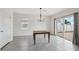 Dining room with modern chandelier and sliding glass door leading to a brick-paved backyard at 31398 Penny Surf Loop, Wesley Chapel, FL 33545