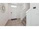 Bright entryway featuring tile floors, a staircase, coat closet, and decorative mirror at 31398 Penny Surf Loop, Wesley Chapel, FL 33545