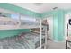 Bedroom featuring white bunk beds with comfy bedding and a mint accent wall at 3251 Shoal Line Blvd, Hernando Beach, FL 34607