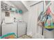 Efficient laundry room with washer, dryer, shelving, and storage bins at 3251 Shoal Line Blvd, Hernando Beach, FL 34607