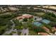 Aerial view of the community amenities including the pool, tennis courts, clubhouse, and surrounding homes at 329 Greenwich Cir, Spring Hill, FL 34609