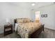 Serene bedroom with neutral tones, wood-look tile flooring, and a view into the ensuite bathroom for a relaxing retreat at 4142 Montegrappa Way, Wesley Chapel, FL 33543