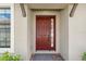 Inviting entryway featuring a red front door with sidelight window and stone pavers for a welcoming appeal at 4142 Montegrappa Way, Wesley Chapel, FL 33543