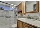 Bathroom featuring a shower with marble tiles and a wooden cabinet with mirror at 4560 Lamson Ave, Spring Hill, FL 34608