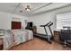 Bedroom featuring a treadmill, desk and chair and a large comfortable bed at 4560 Lamson Ave, Spring Hill, FL 34608