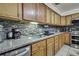 Traditional kitchen featuring stainless steel appliances, granite countertops, and tile backsplash at 4560 Lamson Ave, Spring Hill, FL 34608