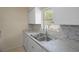 Bright kitchen featuring stainless steel sink, patterned backsplash, and window for natural light at 520 Copperfield Rd, Spring Hill, FL 34606