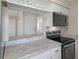 Kitchen with stainless steel oven and microwave, white cabinetry, and an open view to the side rooms at 520 Copperfield Rd, Spring Hill, FL 34606