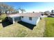 Well-maintained backyard showing a sunroom addition, providing a bright and airy extension of the home at 5441 Mosaic Dr, Holiday, FL 34690