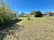 Large grassy backyard with partial view of a sunroom at 5441 Mosaic Dr, Holiday, FL 34690