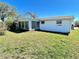 Expansive backyard featuring a sunroom addition and lush green grass, creating a serene outdoor space at 5441 Mosaic Dr, Holiday, FL 34690