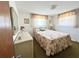 Comfortable bedroom featuring a floral-patterned bed, dresser, and ample natural light at 5441 Mosaic Dr, Holiday, FL 34690
