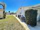 Exterior side yard with well-maintained lawn, walkway and modern AC unit at 5441 Mosaic Dr, Holiday, FL 34690