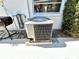 Exterior view of a modern air conditioning unit, complemented by a nearby grill at 5441 Mosaic Dr, Holiday, FL 34690