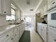 Bright galley kitchen with white cabinets, ample counter space, and stainless steel appliances at 5441 Mosaic Dr, Holiday, FL 34690
