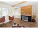 Inviting living area featuring wood floors, a modern fireplace, and a view into the kitchen area at 5590 77Th N Ave, Pinellas Park, FL 33781