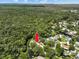 Aerial view of a house nestled among lush trees and a beautiful river, with a faint ocean view in the distance at 6090 Waverly Rd, Weeki Wachee, FL 34607