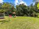 Backyard view shows patio area, grassy lawn, and river access with mature trees at 6090 Waverly Rd, Weeki Wachee, FL 34607