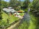 Charming riverfront home featuring a lovely lawn, covered patio area, and private access to the pristine, clear river at 6090 Waverly Rd, Weeki Wachee, FL 34607