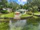 A charming riverfront home featuring a lovely lawn, covered patio area, and private access to the pristine, clear river at 6090 Waverly Rd, Weeki Wachee, FL 34607