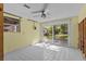 Unfinished living room featuring tile flooring, sliding doors, and ceiling fan at 6090 Waverly Rd, Weeki Wachee, FL 34607