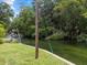Lush river with small boats floating by along the bank, lined with vibrant trees and green grass at 6090 Waverly Rd, Weeki Wachee, FL 34607
