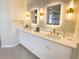 A stylish bathroom is complete with dual sinks, modern lighting, and gold hardware and fixtures at 6393 Pinehurst Dr, Spring Hill, FL 34606