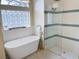 Soaking tub and shower offer a spa-like experience with high-end fixtures and a unique glass block window at 6393 Pinehurst Dr, Spring Hill, FL 34606