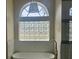 Bright bathroom featuring a soaking tub beneath a window with glass block for privacy at 6393 Pinehurst Dr, Spring Hill, FL 34606