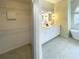 Bright bathroom featuring double sinks, hexagon tile accent wall, and soaking tub at 6393 Pinehurst Dr, Spring Hill, FL 34606