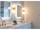 Modern bathroom featuring a double vanity, illuminated mirrors, hexagon backsplash, and gold hardware at 6393 Pinehurst Dr, Spring Hill, FL 34606