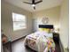 Bright bedroom with a large window, ceiling fan, and colorful bedding at 6393 Pinehurst Dr, Spring Hill, FL 34606