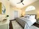 Cozy bedroom featuring a stylish ceiling fan, large arched window, and modern decor at 6393 Pinehurst Dr, Spring Hill, FL 34606