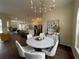 This dining area features an open floor plan with elegant white chairs and modern lighting at 6393 Pinehurst Dr, Spring Hill, FL 34606