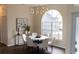 Bright dining room featuring a modern chandelier, round table, and a large arched window at 6393 Pinehurst Dr, Spring Hill, FL 34606
