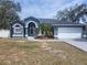 Charming blue single-story home with well-manicured landscaping, arched entry, and a two-car garage at 6393 Pinehurst Dr, Spring Hill, FL 34606