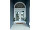 Elegant arched double front doors welcome you home with decorative plants and a welcome mat at 6393 Pinehurst Dr, Spring Hill, FL 34606
