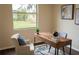 Comfortable home office featuring a wood desk, neutral walls, a large window with backyard view, and natural lighting at 6393 Pinehurst Dr, Spring Hill, FL 34606