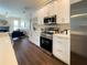 Bright kitchen featuring white cabinets, stainless steel appliances, and a view into the living area at 6393 Pinehurst Dr, Spring Hill, FL 34606