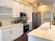 Modern kitchen with white cabinets, stainless steel appliances, and quartz countertops with gold hardware at 6393 Pinehurst Dr, Spring Hill, FL 34606