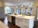 Large kitchen island with a sink, white cabinets, and modern gold hardware, opening to the dining area at 6393 Pinehurst Dr, Spring Hill, FL 34606