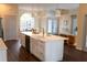 Spacious kitchen island featuring a white countertop with brass faucet and seating at 6393 Pinehurst Dr, Spring Hill, FL 34606