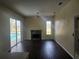 Living room with fireplace and sliding glass doors overlooking the pool at 6393 Pinehurst Dr, Spring Hill, FL 34606