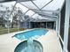 Enjoy the pool and integrated hot tub in the screened pool area at 6393 Pinehurst Dr, Spring Hill, FL 34606
