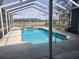Inviting screened-in pool and hot tub with serene views of the expansive backyard at 6393 Pinehurst Dr, Spring Hill, FL 34606
