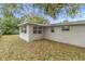 An exterior view of the home showcasing the backyard and enclosed sunroom at 7037 Green St, New Port Richey, FL 34652