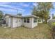 View of the backyard with an AC unit, and windows providing natural light to the enclosed space at 7037 Green St, New Port Richey, FL 34652